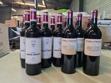 six bouteilles de vin sont alignées sur une table dans un entrepôt