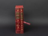two red books sitting on top of each other on a black surface