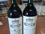 deux bouteilles de vin rouge posées sur une table en bois