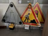 trois panneaux de signalisation posés par terre près d'une fenêtre