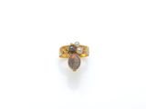 a close up of a gold ring with an oplite and pearl