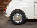 a small white car parked in front of a brick wall