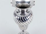 a silver vase that is sitting on a table
