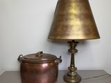 a lamp that is next to a pot on a table