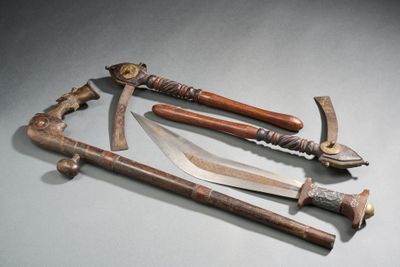 Plusieurs types d'armes sont exposés sur une surface grise