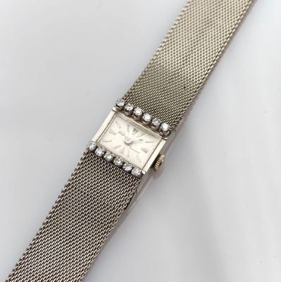 a close up of a watch on a white surface with a white background