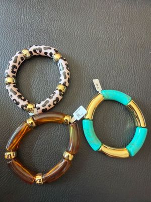 trois bracelets à imprimé léopard et détails dorés sur une base en cuir noir