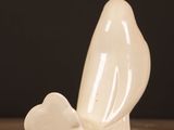 a white sculpture of a bird sitting on a table