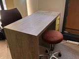 a desk with a chair in front of a window
