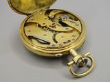 une montre de poche en or à laquelle est attachée une chaîne