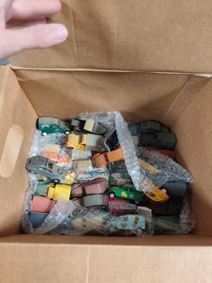 une boîte en carton remplie de petites voitures de toutes sortes