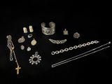 a collection of silver jewelry on a black background