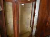 a corner cabinet with a marble top and a glass door