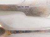 two spoons and a fork on a white table