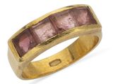 un gros plan d'une bague en or sertie de pierres roses