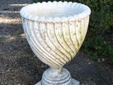 a white urn sitting in the middle of a gravel area