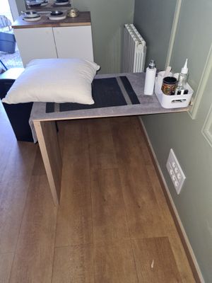 une petite table sur laquelle est posé un coussin, dans un coin de la pièce