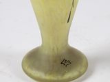 a yellow vase with a bird on it on a white surface