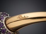 a close up of a gold ring with purple stones on it