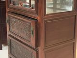 a display case with a glass door and a drawer