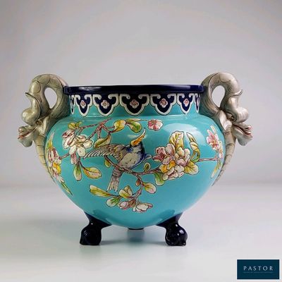 un vase bleu orné d'un oiseau et de fleurs