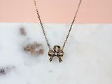 gold plated skull and crossbone necklace on a marble surface