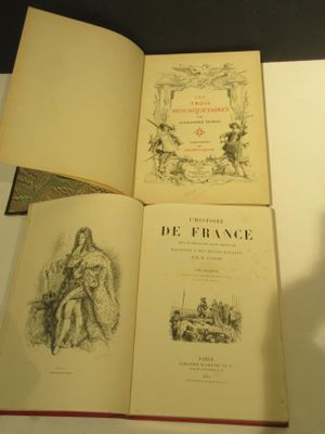 three books sitting on a table with a shadow of a person