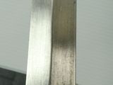 a silver knife on a wooden stand on a table
