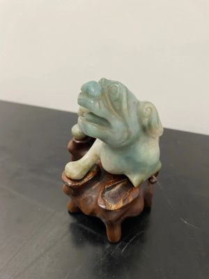 a figurine of a frog sitting on top of a table