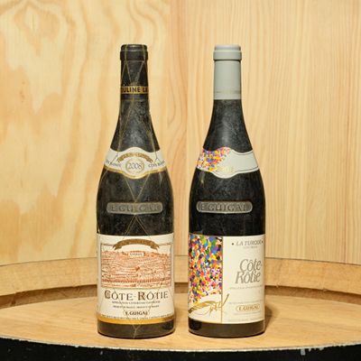 two bottles of wine sitting on top of a barrel