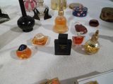 de nombreux parfums différents posés sur une table, avec un miroir en arrière-plan