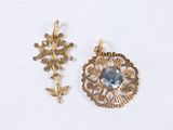 two pieces of jewelry are shown on a white surface