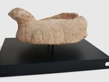 a sculpture of a bird on a stand on a white background