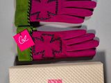 two pairs of pink and green gloves sitting on top of a white box