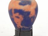a blue and orange vase sitting on a black stand