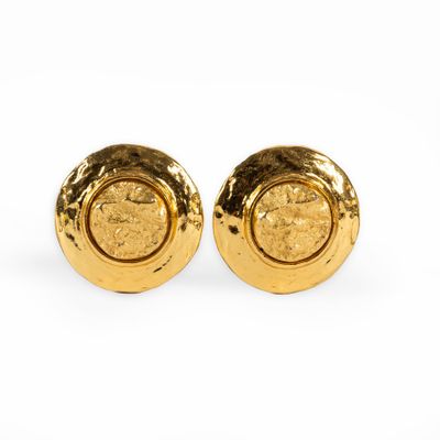 a pair of gold toned earrings with a circular design