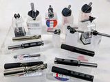 many different types of pens and pencils sitting on a table