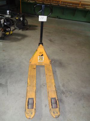 un chariot élévateur dans un garage, sur lequel est accrochée une pancarte