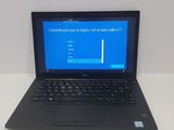 laptop computer sitting on top of a white table with a blue screen