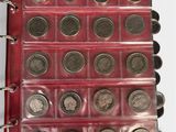 a lot of coins in a red binder on a table