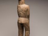 a statue of a man standing on a wooden base