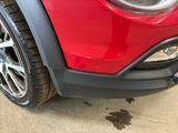 the front end of a red jeep parked in a parking lot