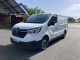 une camionnette blanche garée sur un parking à côté d'un bâtiment