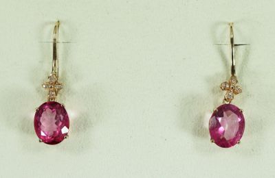 deux paires de boucles d'oreilles ornées de pierres roses sur un fond blanc