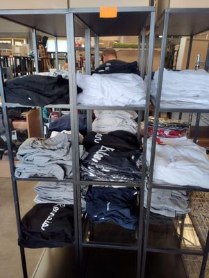 il y a beaucoup de t-shirts sur les étagères du magasin