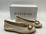 une paire de chaussures blanches ornées d'un anneau doré sur la pointe