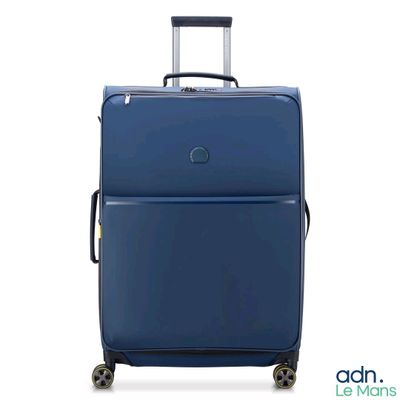 une valise bleue à roulettes sur fond blanc