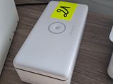une batterie externe blanche posée sur une table à côté d'un ordinateur portable