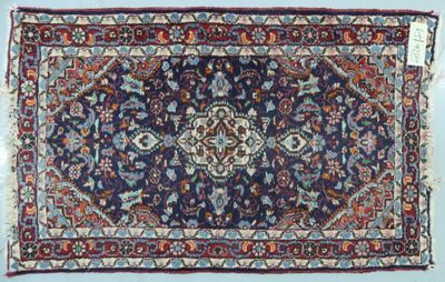 un tapis oriental à fond bleu et bordure rouge