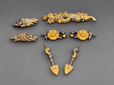 six bijoux en or et en argent posés sur un fond gris